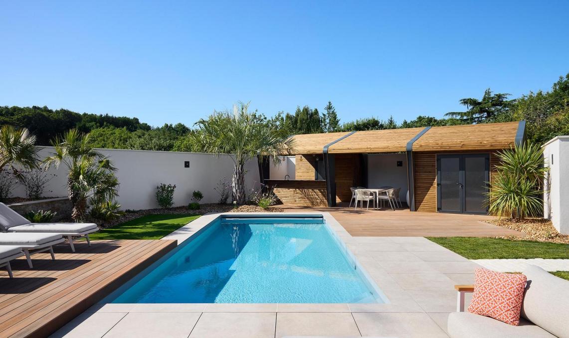 Piscine rectangulaire entourée de lames Nuances Ipé Silvadec, transats et salon de jardin, réalisation O'xygen Paysagist